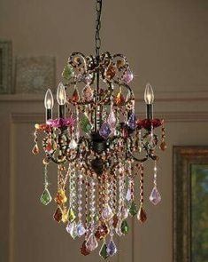 a chandelier hanging from the ceiling with lots of colorful beads and crystals on it