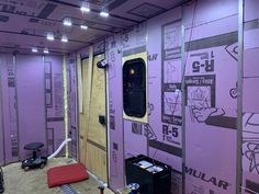 an unfinished room with purple walls and electrical equipment