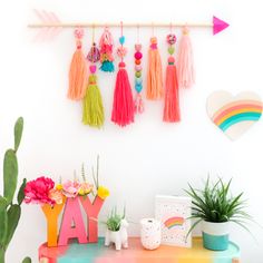 the wall is decorated with colorful tassels and cactuses, such as succulents