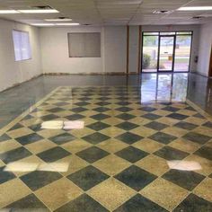 an empty room with checkered floor and windows