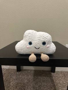 a stuffed cloud sitting on top of a black table