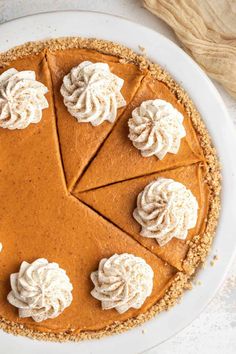 an overhead view of a pumpkin pie with whipped cream on top