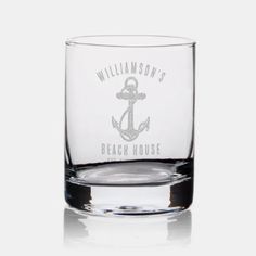 a shot glass with an anchor on the front and beach house written in white ink