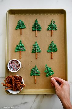 a tray with pretzels decorated like christmas trees and sprinkles on them