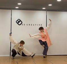 two people doing tricks in front of a wall with the words dd creative on it