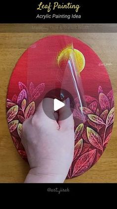 someone using acrylic paint to decorate a red plate with leaves and lemons