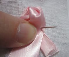 the needle is being used to sew something pink