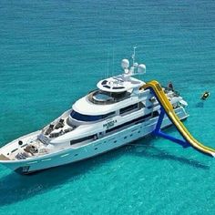 a large white boat in the ocean with a slide on it's back end