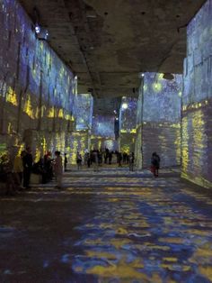 people are standing in the middle of an underground tunnel with blue and yellow lights on it