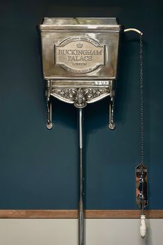 an antique silver mailbox with chains hanging from it's sides on a wall