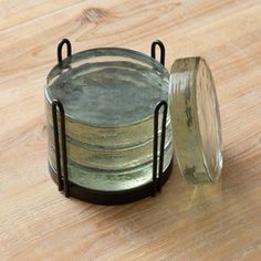 a glass jar sitting on top of a wooden table next to a metal holder with two rings