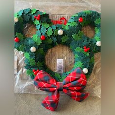 a wreath shaped like a heart with holly leaves on it