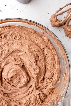 a bowl filled with chocolate frosting on top of a table