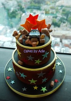 a three tiered cake with cars and stars on it