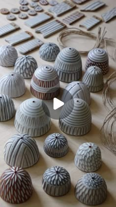 several different types of ceramic objects on a table with string and scissors in the background