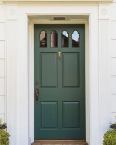 a green front door on a white house