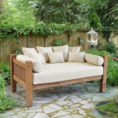 a wooden couch sitting on top of a stone patio