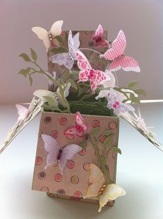 a vase filled with paper butterflies on top of a table