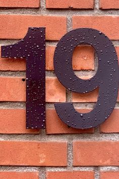 the number nine is displayed on a brick wall