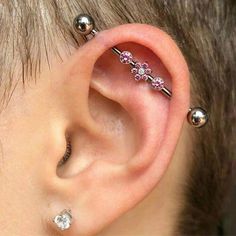 an ear piercing with pink flowers on it