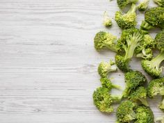 broccoli florets on a white wooden table with space for text or image