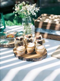 some cupcakes are sitting on a wooden tray