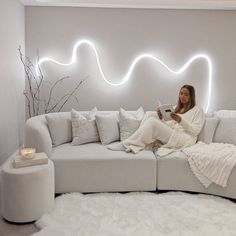 a woman sitting on top of a white couch