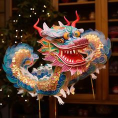 a colorful dragon statue sitting in front of a christmas tree