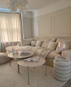 a living room filled with lots of furniture and candles on top of it's coffee table