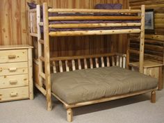 a wooden bunk bed sitting next to a chest of drawers and a night stand with a mattress on it