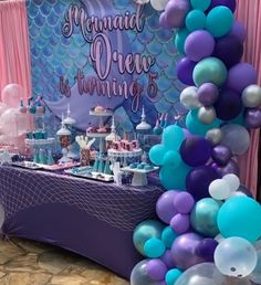 a mermaid themed birthday party with balloons and cake