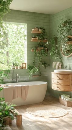 a bathroom with green tiles and plants on the wall, along with a white bathtub