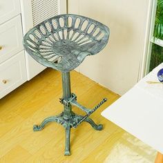 an old metal chair sitting on top of a wooden floor next to a white dresser