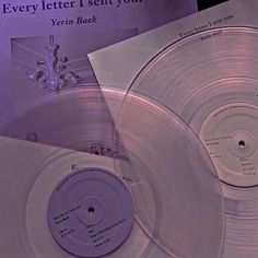 two silver records sitting next to each other on top of a purple sheet with the words every letter i sent you