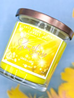 a candle that is sitting on top of a flowery tablecloth with yellow flowers in the background