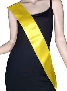 a woman wearing a black dress with a yellow sash around her waist and the back of her body