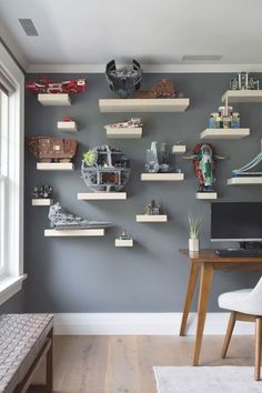 a room with some shelves on the wall and a desk in front of it filled with legos