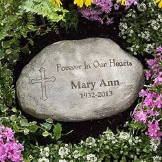 a memorial stone surrounded by flowers and greenery