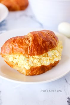 there is a croissant with eggs on it