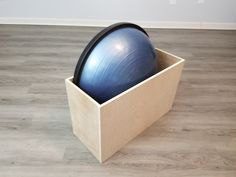 an exercise ball in a wooden box on the floor