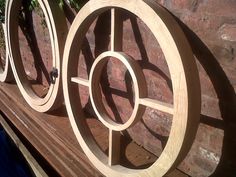 three circular wooden sculptures sitting on top of a bench