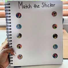 a hand holding a notebook with stickers on it that says match the sticker