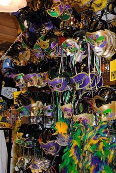 many masks are hanging from the ceiling at a carnival or mardi gras event