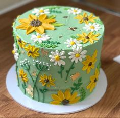 a green cake with yellow and white flowers on it