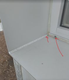 the corner of a window sill with red arrows pointing to it