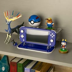 a nintendo wii game system sitting on top of a shelf next to figurines