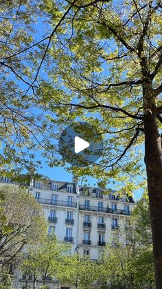 an image of a building in the distance with trees and bushes around it on a sunny day