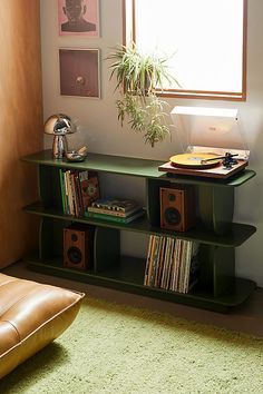 a living room with a couch, bookshelf and plant in the window sill