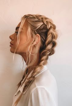 a woman with long blonde hair in a fishtail braid, looking off to the side