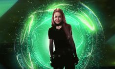 a woman is standing in front of a green background with circles and stars on it